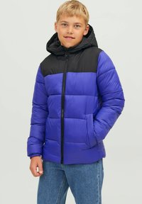 Chaqueta tipo puffer con la mitad inferior de un azul vibrante y la sección superior negra, con capucha, cierre con cremallera y un patrón acolchado en toda su superficie.