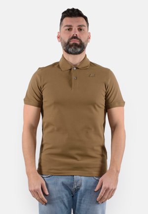 Polo shirt corto marrone a maniche corte con colletto button-down e un logo discreto sul petto. Tessuto liscio e design aderente, abbinato a un denim.