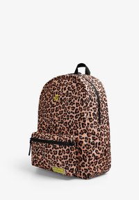 Mochila de estampado de leopardo en tonos marrón y negro. Cuenta con un compartimento principal con cremallera y un bolsillo delantero con cremallera. Incluye una etiqueta con el logotipo amarillo.