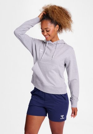 Gray cropped hoodie with a front pocket and drawstring hood, paired with navy shorts featuring a white logo. Smooth texture and casual fit.