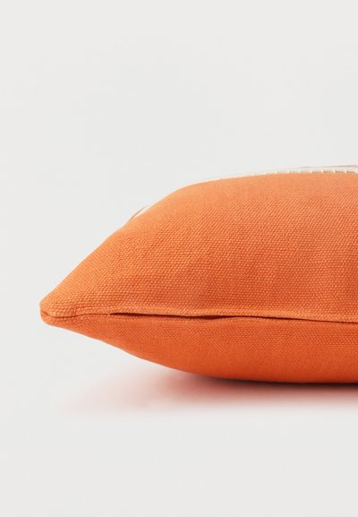 Rectangular orange textured fabric pillow with visible seams, shown from the side against a plain white background.