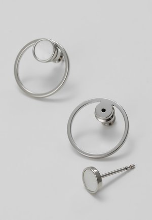 Silver circular stud earrings with open round hoop design, displayed on a plain light gray surface.