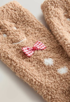 Braune, flauschige Fäustlinge mit einem Lebkuchenmann-Design, ausgestattet mit einer roten Karomuster-Schleife und weißen Akzenten, die Frosting und Knöpfe ähneln.