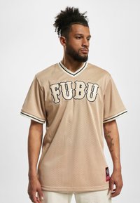 Jerseu din plasă bej cu accente negre și crem, decolteu rotund și litere îndrăznețe "FUBU" pe față. Etichetă pe lateral.