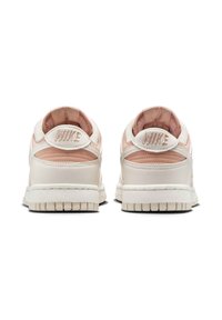 Baskets Nike, matériaux en cuir et en mesh, crème et rose tendre, design basse, languette rembourrée, col rembourré, semelle extérieure texturée, détail du logo.