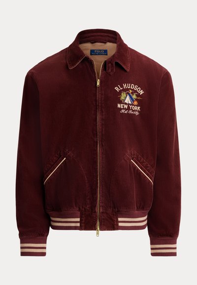 Bordeauxrode corduroy jas met geribbelde manchetten en zoom, voorzien van een gouden ritssluiting, geborduurd "RL Hudson New York"-logo en een lichtbruine voering.