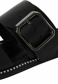 Sandalo in pelle nera con larghe cinghie, fibbia rettangolare argentata e borchie decorative argentate lungo la base. Soletta interna texture.
