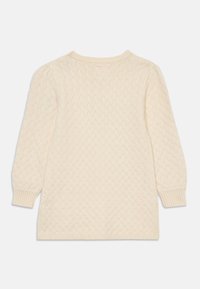 Abito in maglia color crema con un motivo a diamante testurizzato, polsini a costine e scollatura rotonda. Maniche lunghe e design a metà lunghezza.
