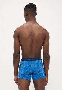 Kék boxer alsónemű, ismétlődő "LEVI'S" felirattal, rugalmas derékpánttal és testhez álló fazonnal, sima anyagtextúrával.