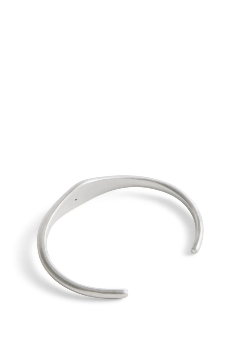 Bracciale in argento con una superficie liscia e lucida, caratterizzato da un design elegante e minimalista e estremità aperte per una vestibilità regolabile.