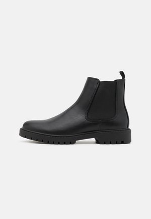Black leather Chelsea boot with elastic side panel, pull tab at heel, and lugged rubber sole, shown in side profile on white background.