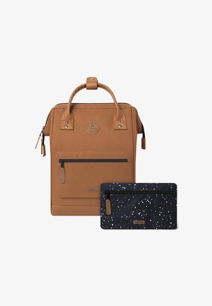 Sac en tissu beige avec des accents en cuir marron et une poche zippée à l'avant, associé à un classeur bleu marine ornée de taches multicolores et d'une fermeture zippée.