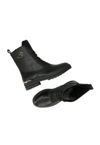 Černé kožené kotníkové boty s texturovaným síťovaným svrškem, kulatou špičkou, šněrovacím designem a metalickým akcentem na patě. Gumová podešev pro lepší trakci.