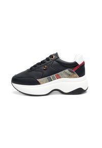 Black synthetic sneaker with a textured fabric panel featuring beige, green, and red stripes. Thick white sole and black accent details.