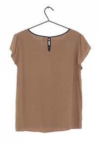 Brun kortærmet bluse med et diskret geometrisk mønster, en nøglehulåbning bagpå og en kontrastfarvet marineblå halsudskæring. Letvægtsstof.