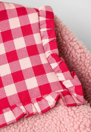 Fleece tæppe med pink, blød tekstur og en mønstret flæse i rødt og lyserødt ternet design. Kanterne er frynset og samlet.