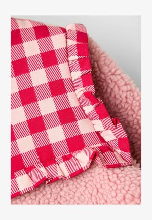 Fleece deken met een zachte, roze textuur en een gekruide ruffle in een rood en lichtroze geruit ontwerp. De randen zijn rafelig en verzameld.