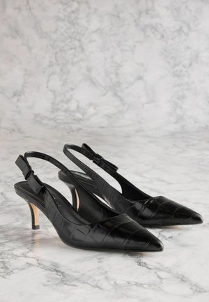 Černé lakované kožené lodičky na podpatku s špičatou špičkou, texturovaným krokodýlím vzorem, nastavitelností přezky a štíhlým, nízkým podpatkem.