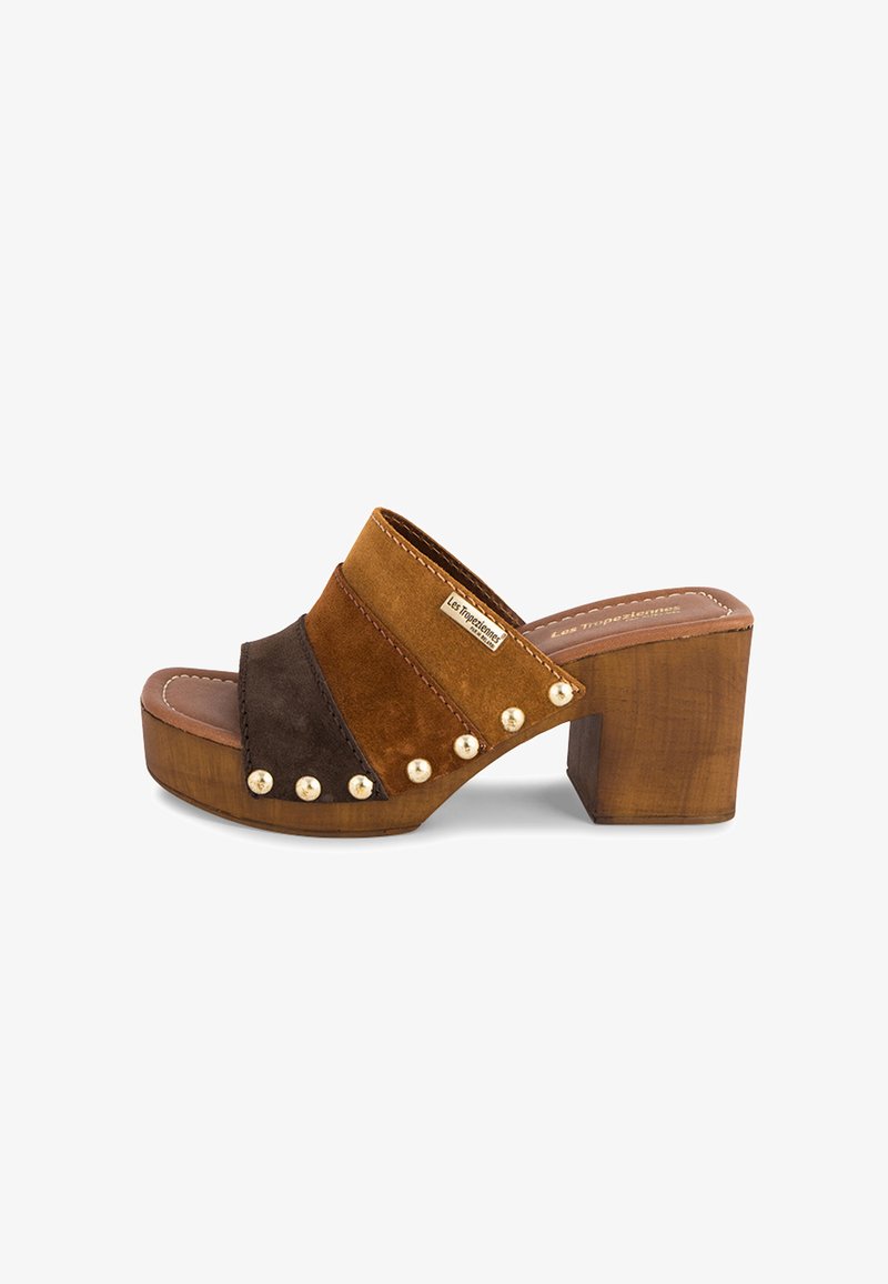 Sandale à enfiler en daim marron avec un talon en bois épais. Comprend trois brides en bloc de couleurs et des accents de clous dorés sur le côté.