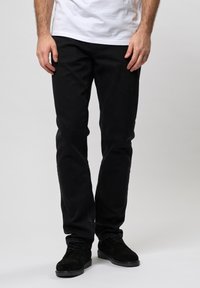 Jeans negri din denim cu croială slim. Prezintă cusături subtile și o ușoară decolorare. Asortați cu încălțăminte din suede negru.