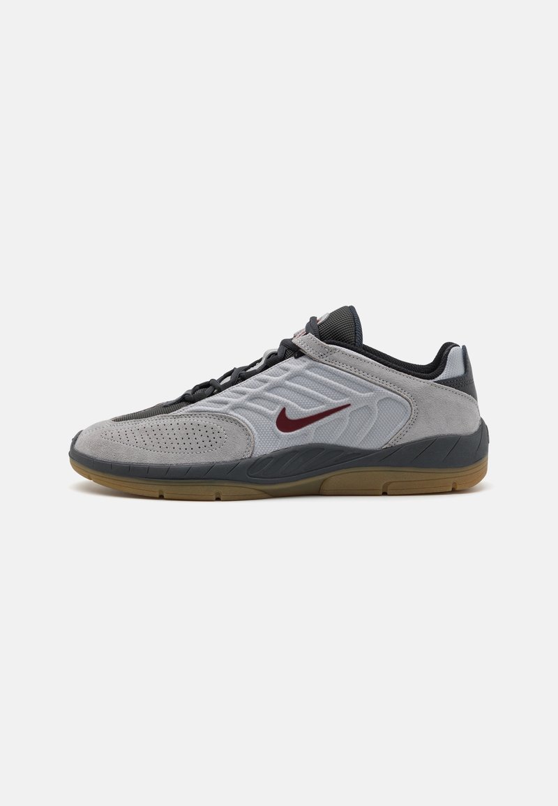 Baskets basses grises et noires avec le logo Nike bordeaux, tige en daim et mesh, lacets noirs, et semelle en gomme.