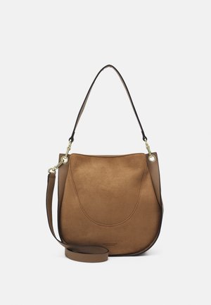 Sac à bandoulière en daim marron et cuir avec bandoulière réglable et ferrures dorées, forme arrondie douce et nom de marque discrètement embossé.