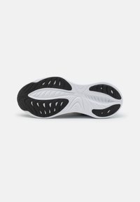Suola della scarpa con una combinazione di colori bianco e nero, in gomma texture con molteplici scanalature e motivi per una migliore aderenza e flessibilità.