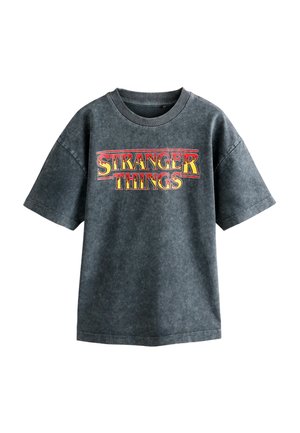 Tamsiai pilka medvilninė marškinėlių su trumpomis rankovėmis ir apvaliu iškirpimu. Priekyje yra raudonu ir geltonu atspaudiniu „Stranger Things“ logotipas.