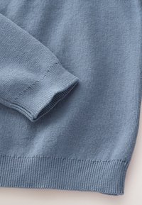 Svetlomodrý pletený sveter s rebrovanými lemami na manžetách a spodnej časti. Hladká textúra s jednoduchým, klasickým dizajnom.