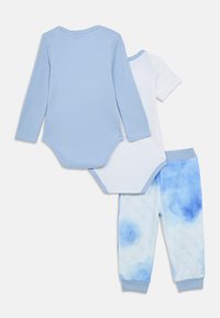 Τρία είδη παιδικών ρούχων: ένα γαλάζιο κορμάκι με μακριά μανίκια, ένα λευκό κορμάκι με κοντά μανίκια και παντελόνι με μοτίβο σε μπλε βαθμίδες.