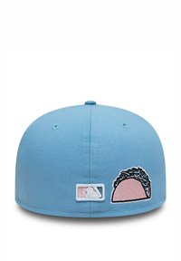 Cappello da baseball blu aderente con un patch ricamato a forma di taco e una piccola etichetta MLB sul lato. Tessuto morbido al tatto, corona rotonda.