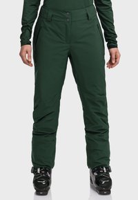 Grüne Skihosen aus wasserdichtem Material; mit geradem Schnitt, Reißverschlusstaschen und einem Gürtel mit zwei vorderen Knöpfen.
