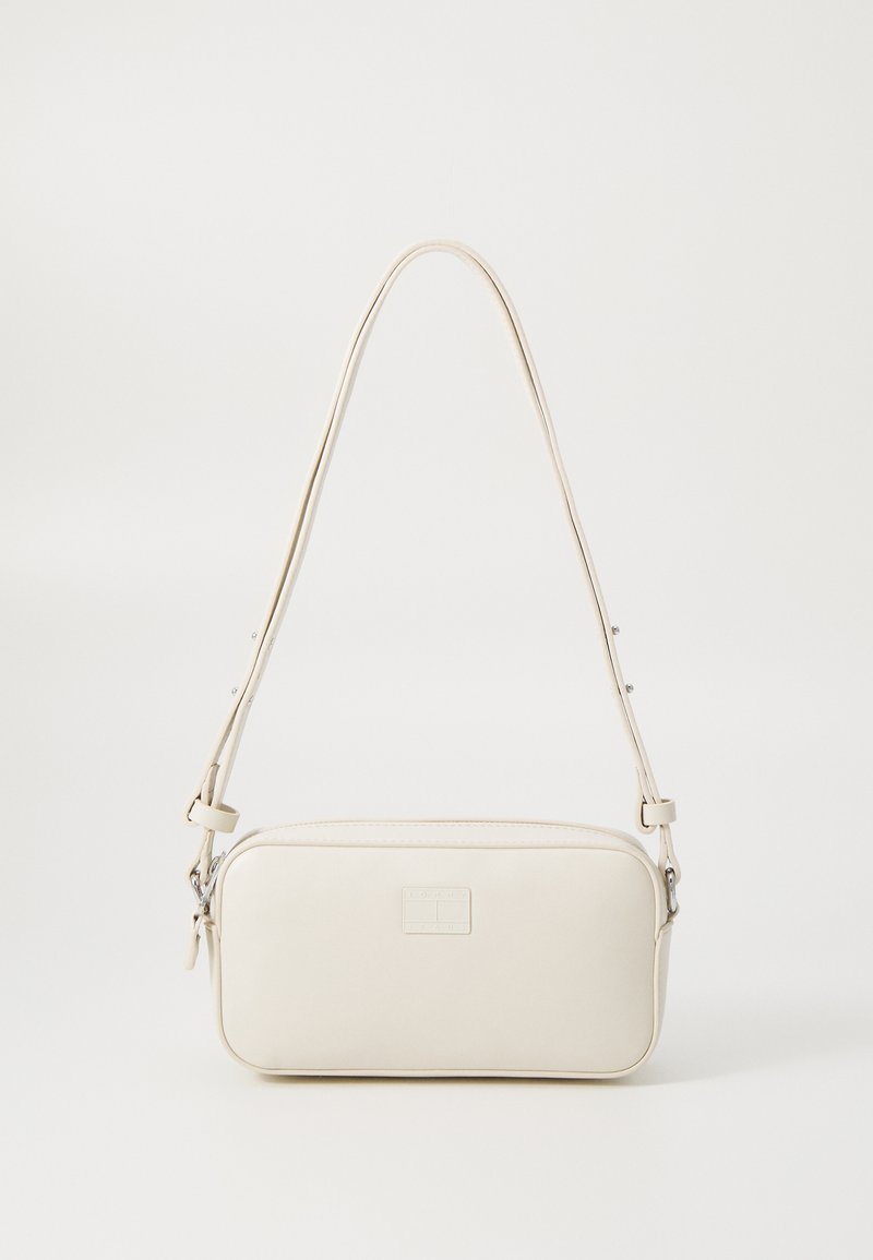 Κρεμ faux δερμάτινη τσάντα ώμου σε ορθογώνιο σχήμα, με φερμουάρ, ρυθμιζόμενο λουρί και λεπτή λεπτομέρεια λογοτύπου στο μπροστινό μέρος.