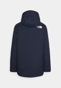 Tmavě modrá izolovaná bunda s kapucí, s hladkou texturou a bílým logem na horní části zad. Rovný střih, dlouhé rukávy.