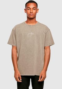 Tricou cu mânecă scurtă, gât rotund, din bumbac de culoare bej deschis, cu un design subtil brodat cu lămâie pe partea stângă a pieptului. Croi clasic.