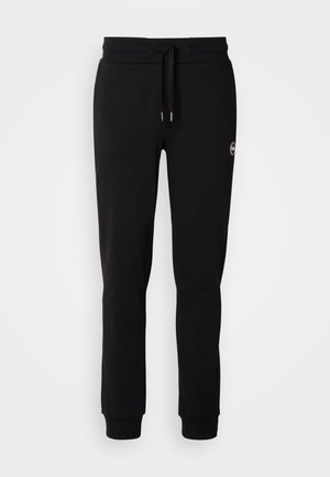 Pantaloni sportivi neri in cotone con vita regolabile, gambe affusolate, polsini a coste e un piccolo logo in evidenza sul lato. Texture liscia.