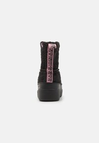 Sort faux fur ankelstøvler med polstret skaft, rosa logo-bånd og svart gummisåle. Har en avrundet tå og myk tekstur.