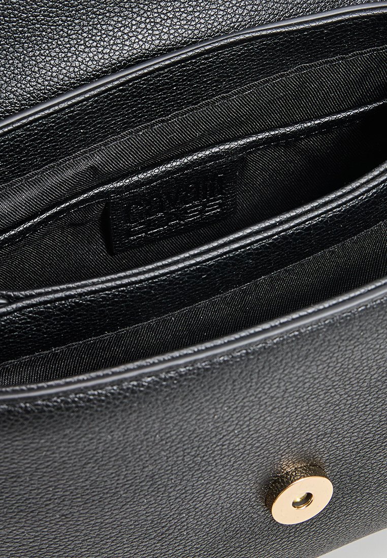 Pochette en cuir noir avec une surface texturée, fermeture à bouton en doré et poche intérieure en satin, mettant en avant un design élégant.
