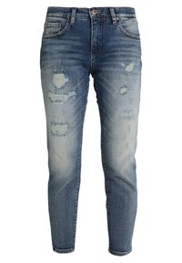 Valaiset siniset farkut denimistä, joissa on kapeampi malli, kuluneet yksityiskohdat, haalistuneet kulmat ja klassinen viisi taskua -tyyli.