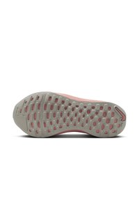 Semelle de chaussure de sport rose clair avec une base en caoutchouc gris texturé, présentant un motif de découpes ovales et circulaires pour l'adhérence.