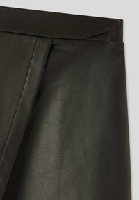 Gonna nera in ecopelle con una texture liscia e un design strutturato. Presenta una vita piegata pulita e dettagli di cucitura minimi.