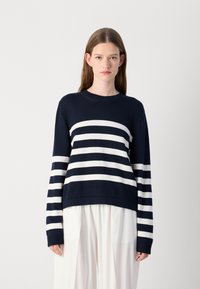 Sweater azul marinho com riscas brancas, gola redonda e mangas longas. Feito de material de malha texturada, apresenta um corte relaxado.