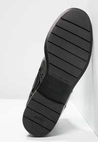 Suela de zapato negra con surcos horizontales y agarre texturizado, mostrando el nombre de la marca "Fratelli Rossetti" y "Hecho en Italia" grabados en la goma.