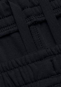 Black fabric showing elasticized sections with stitches and straps woven throughout. Features a textured surface with varying thicknesses.
