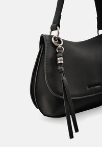 Sac à bandoulière en cuir noir avec une forme incurvée, des ferrures argentées et des tassels décoratifs. Texture lisse avec des détails de couture subtils.