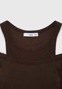 Débardeur marron avec un col large et des bretelles fines. Tissu doux et extensible avec une étiquette affichant la taille et la marque. Les bords sont soigneusement cousus.