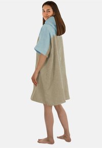 Hooded Frottee-Toweldress in Hellblau und Beige, mit kurzen Ärmeln, weit geschnitten und mit Seitenschlitzen für Bewegungsfreiheit.