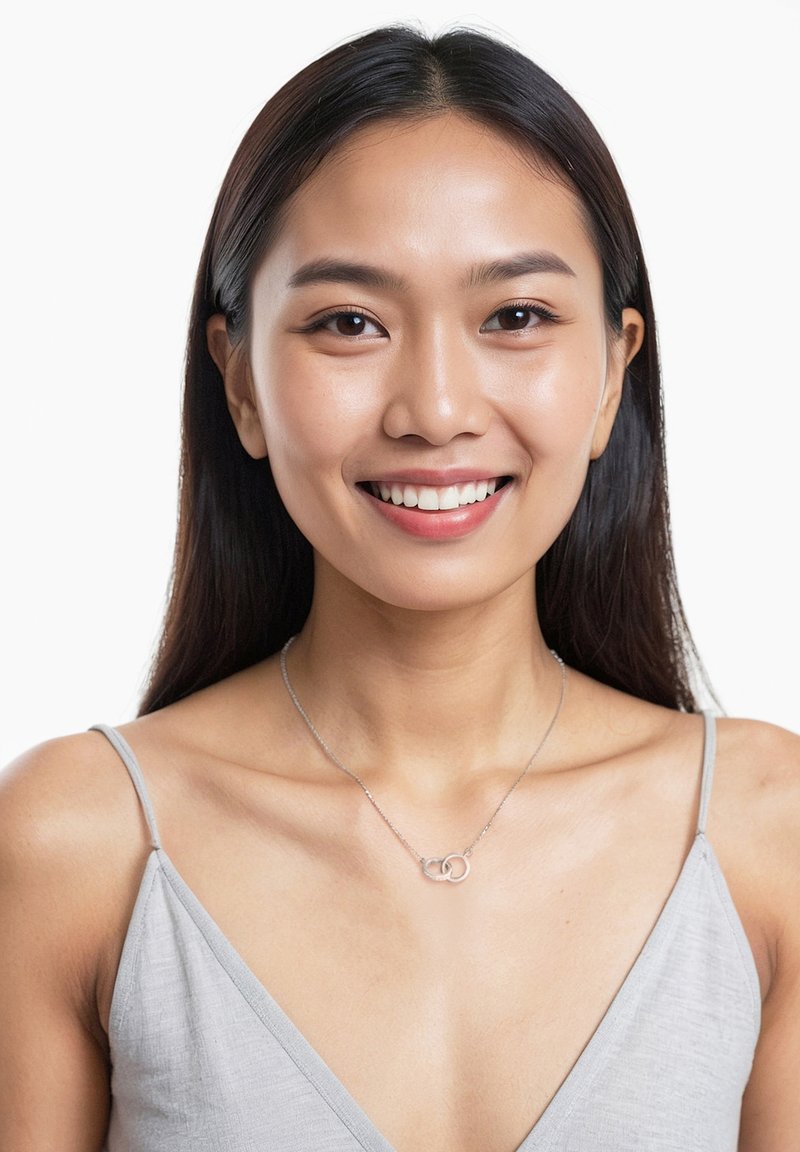 Silverhalsband med två sammanflätade ringar, bärs över en ljusgrå topp med tunna axelband och V-ringning. Slät, glänsande yta.