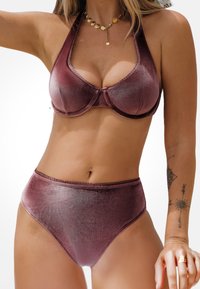 Bikini zestaw z wysokim stanem w ciemnej burgundowej kolorystyce. Materiał wydaje się błyszczący, z solidnymi miseczkami i dekoracyjnym wykończeniem.