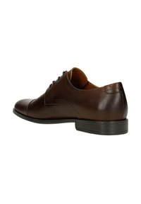 Scarpe in pelle marrone con una finitura liscia, punta arrotondata, tacco basso e sei fori per i lacci. Sottile cucitura che accentua i lati.